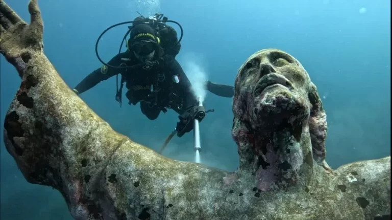 realizan limpieza de la escultura del cristo del abismo en el fondo marino italiano