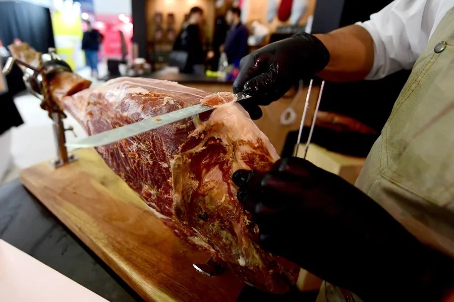 Una persona corta jam&oacute;n serrano durante la inauguraci&oacute;n de la feria ganadera y agroindustrial este viernes, en Montevideo