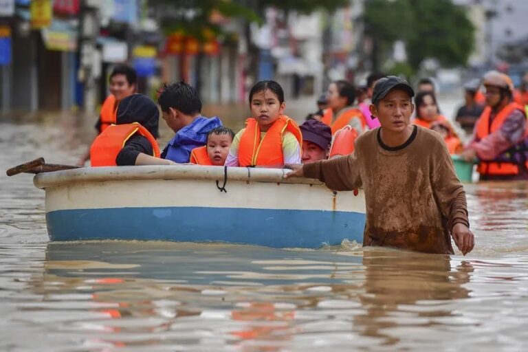 Personas caminan entre las aguas de las inundaciones en Nha Trang, provincia de Khanh Hoa, Vietnam
