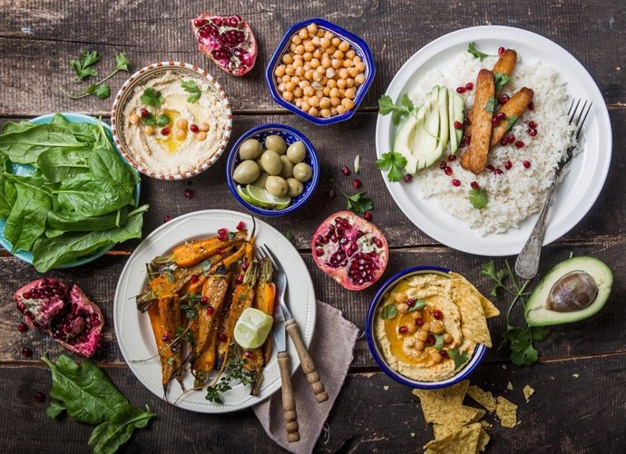 Archivo - Hummus, zanahorias asadas, arroz con tempeh en cuencos de cer&aacute;mica vistos desde arriba, alimentos a base de verduras.