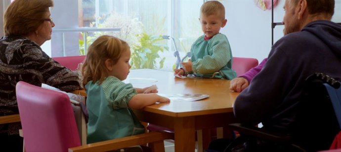 Niños y mayores comen juntos.