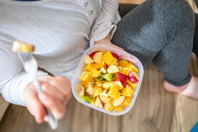 Archivo - Mujer comiendo una ensalada de frutas