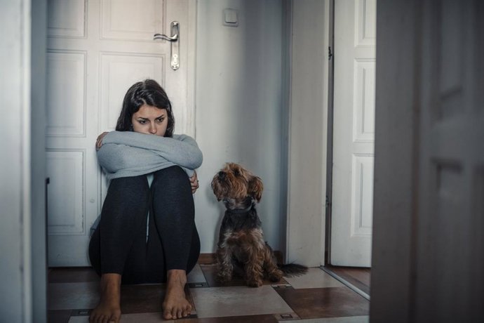 Archivo - Mujer con problemas mentales está sentado exhausto en el suelo con su perro